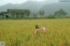 A naked woman sitting on a wooden bench.