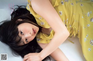 A woman with long black hair wearing a white shirt and orange skirt.