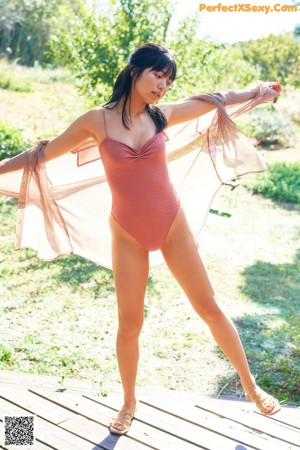 A woman in a pink bathing suit sitting on a couch.