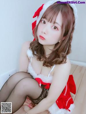 A woman in a red and white dress and a santa hat.