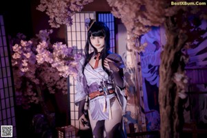 A woman in a kimono holding a samurai sword.