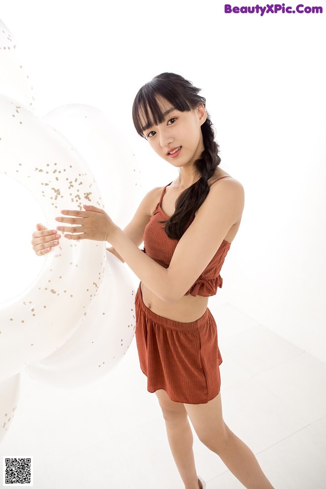 A woman standing in front of a bunch of white balloons.