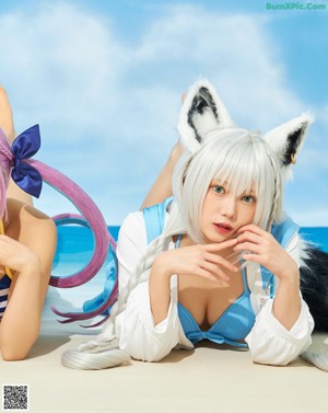 A group of three women in bikinis sitting on a beach chair.