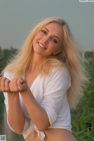 A woman in a pink dress posing for a picture.