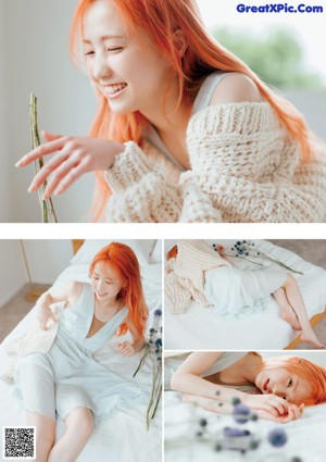 A woman with bright orange hair laying on a bed.